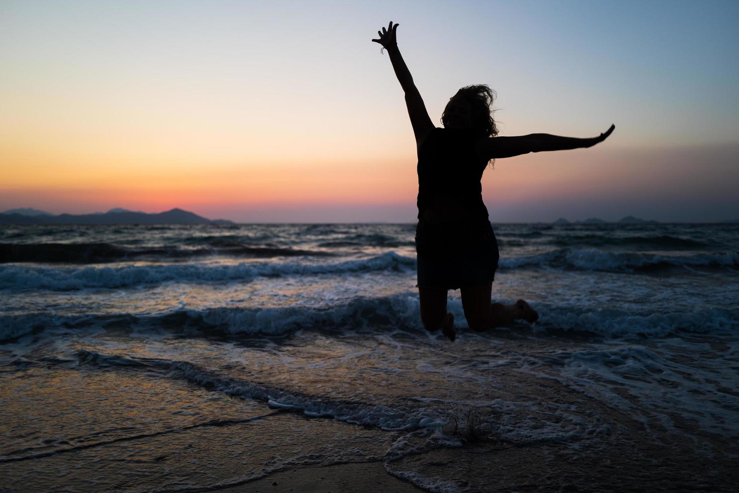 une fille sautant sur kos au coucher du soleil photo