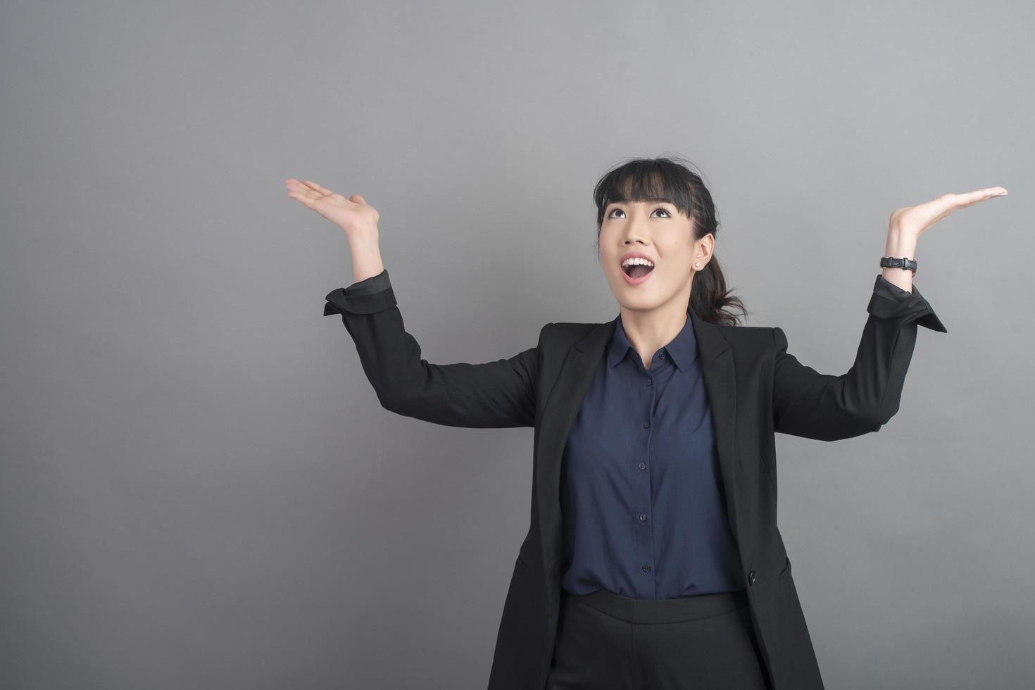 femme d'affaires souriante en blazer sur fond gris photo