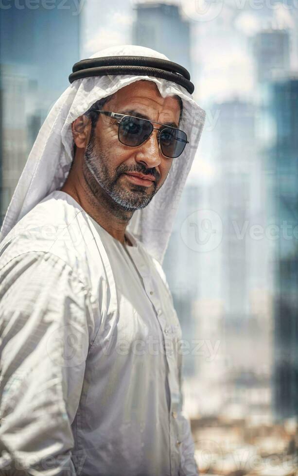 riches arabe homme d'affaire dans traditionnel blanc tenue dans gros ville dans arrière-plan, génératif ai photo