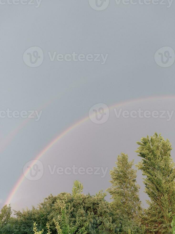 plein arc en ciel après pluie contre le ciel photo