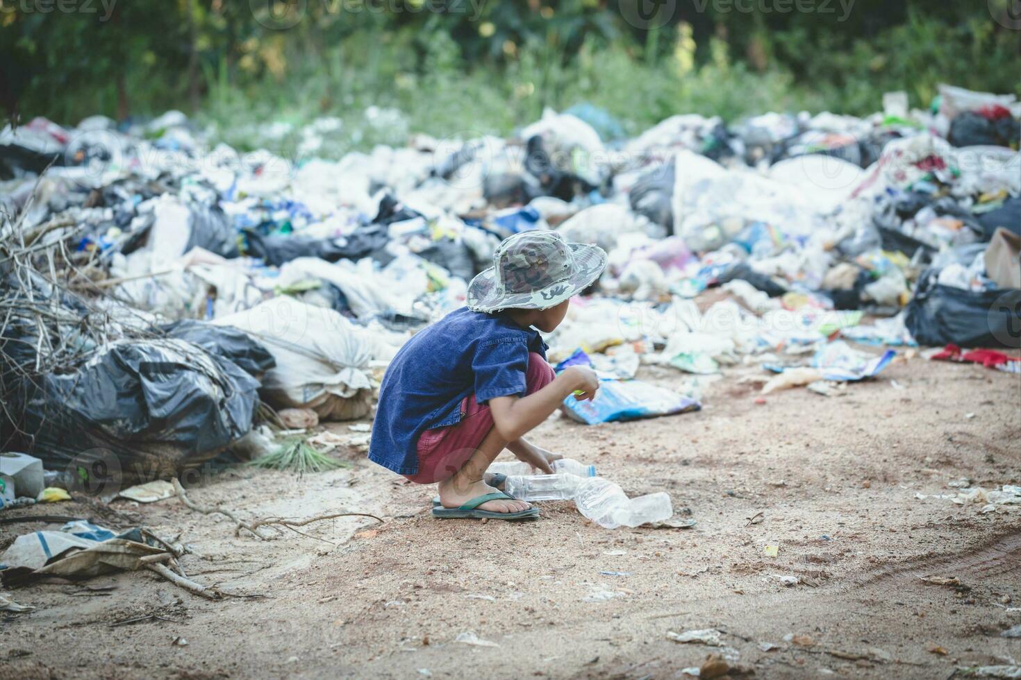 un pauvre garçon ramassant les déchets d'une décharge. concept de moyens de subsistance des enfants pauvres.travail des enfants. travail des enfants, traite des êtres humains, concept de pauvreté photo