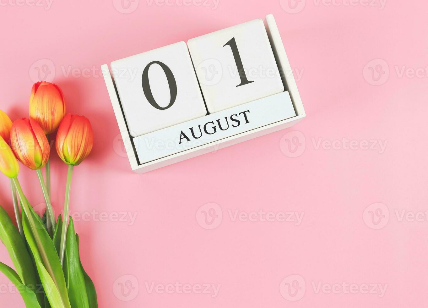 plat allonger de en bois calendrier avec Date août 01 sur rose Contexte avec Orange et Jaune tulipes, copie espace. photo