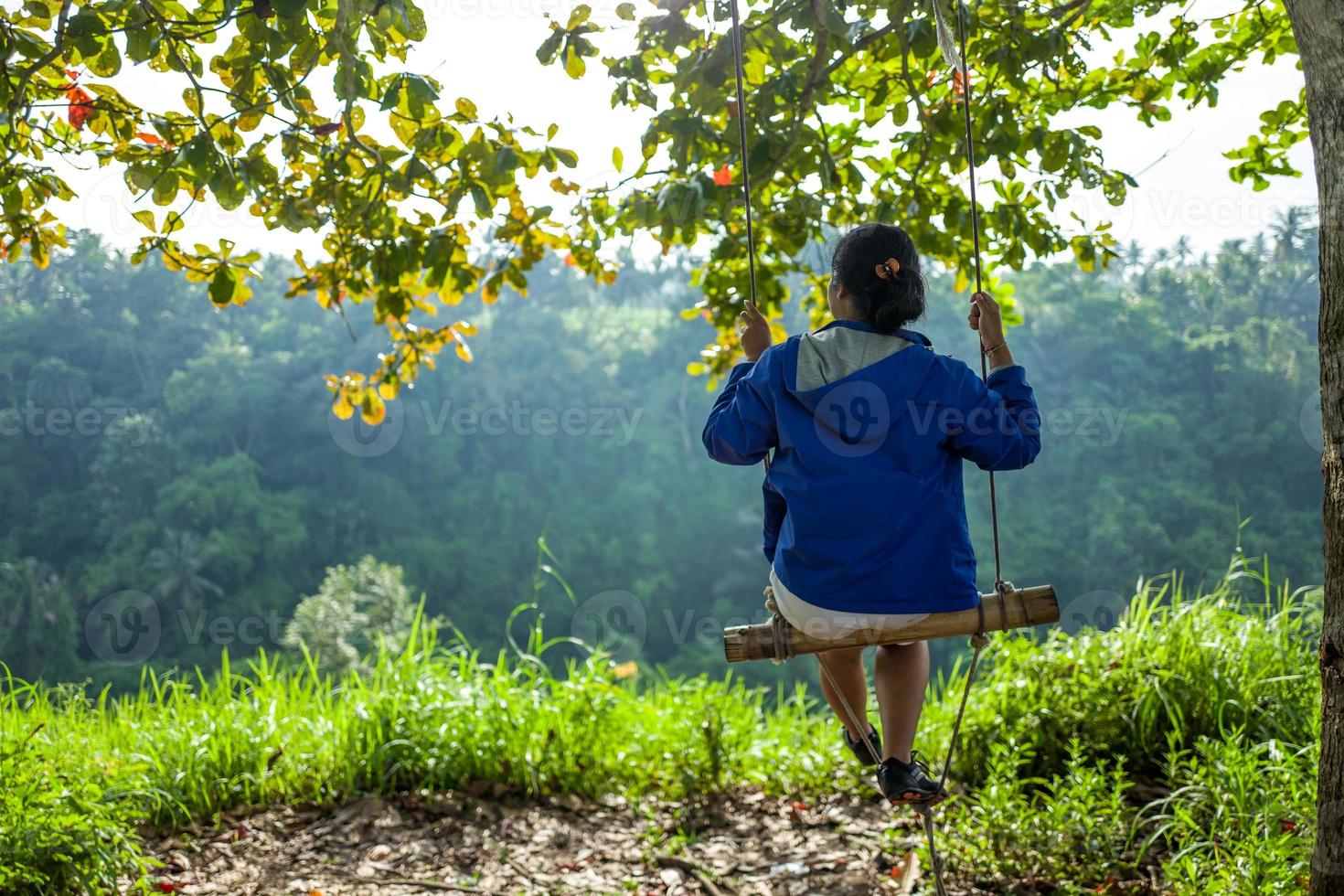 dos de fille sur la balançoire à la promenade de la crête de campuhan à ubud à bali photo