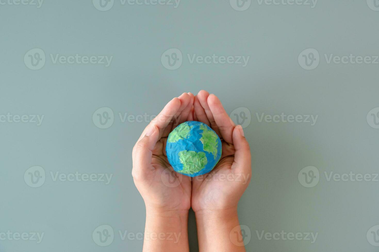 mains en portant Terre papier et l'eau peindre. concept de protéger le monde de global échauffement. durabilité sujet à enregistrer le monde. photo