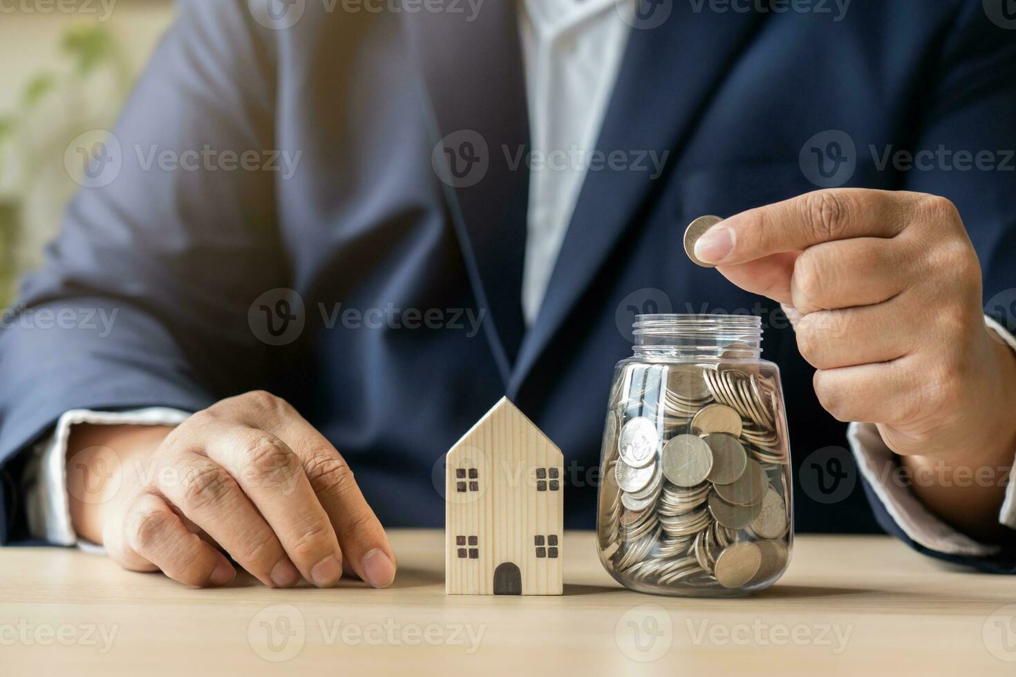 affaires homme travail avec portable des économies argent thaïlandais devise pièces de monnaie dans pot pour Nouveau maison. enregistrer argent à location ou acheter Nouveau vivant lieu. photo