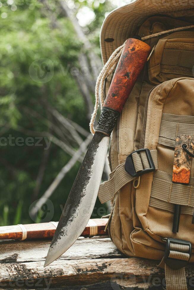 une couteau sac à dos avec équipement pour survie dans le forêt sur un vieux Charpente en bois photo