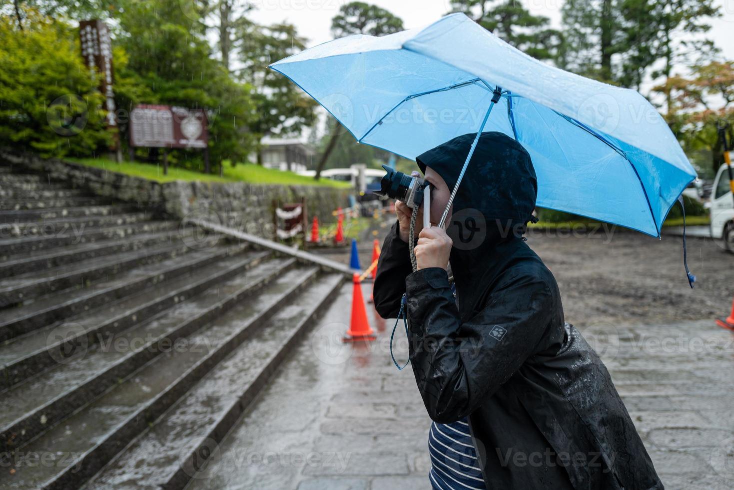 un touriste femla à nikko faisant des photos sous la pluie