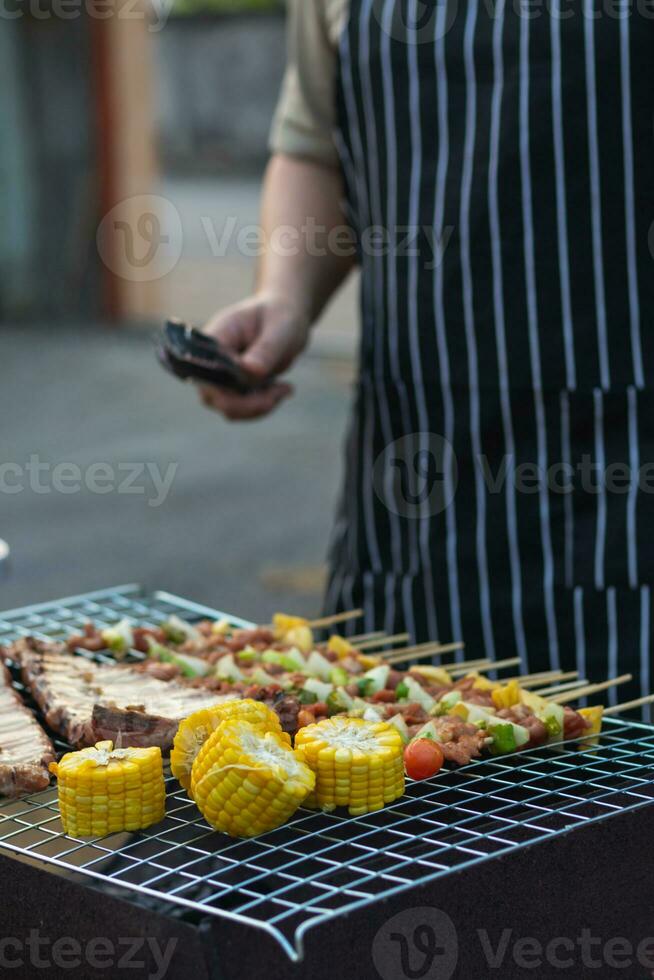 Viande et brochettes Ingrédients pour barbecue fête sont mis sur gril à cuisinier barbecue et faire il prêt pour famille à joindre barbecue fête ce soir. fête Contexte image a copie espace pour texte. photo