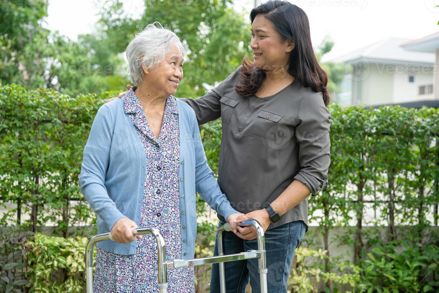 aider et soigner une vieille dame asiatique âgée ou âgée utilise un marcheur en bonne santé tout en marchant au parc pendant de joyeuses vacances fraîches. photo