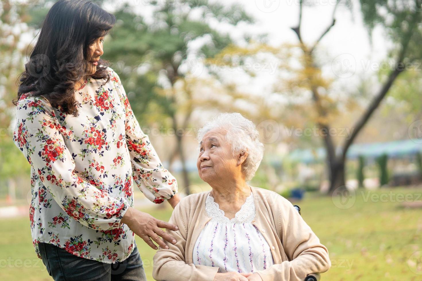 patiente asiatique âgée ou âgée avec soins, aide et soutien sur fauteuil roulant dans le parc en vacances, concept médical fort et sain. photo