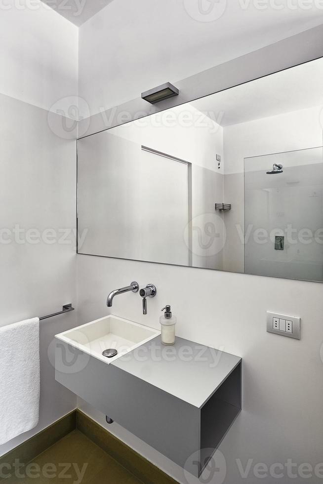 intérieur de salle de bain moderne au premier plan le lavabo avec un grand miroir photo
