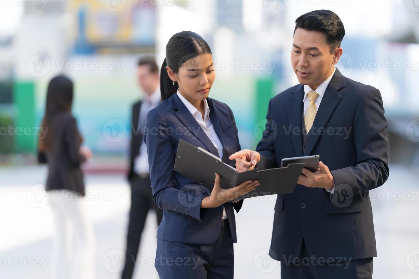 homme d'affaires mature utilisant une tablette numérique pour discuter d'informations avec une femme d'affaires photo