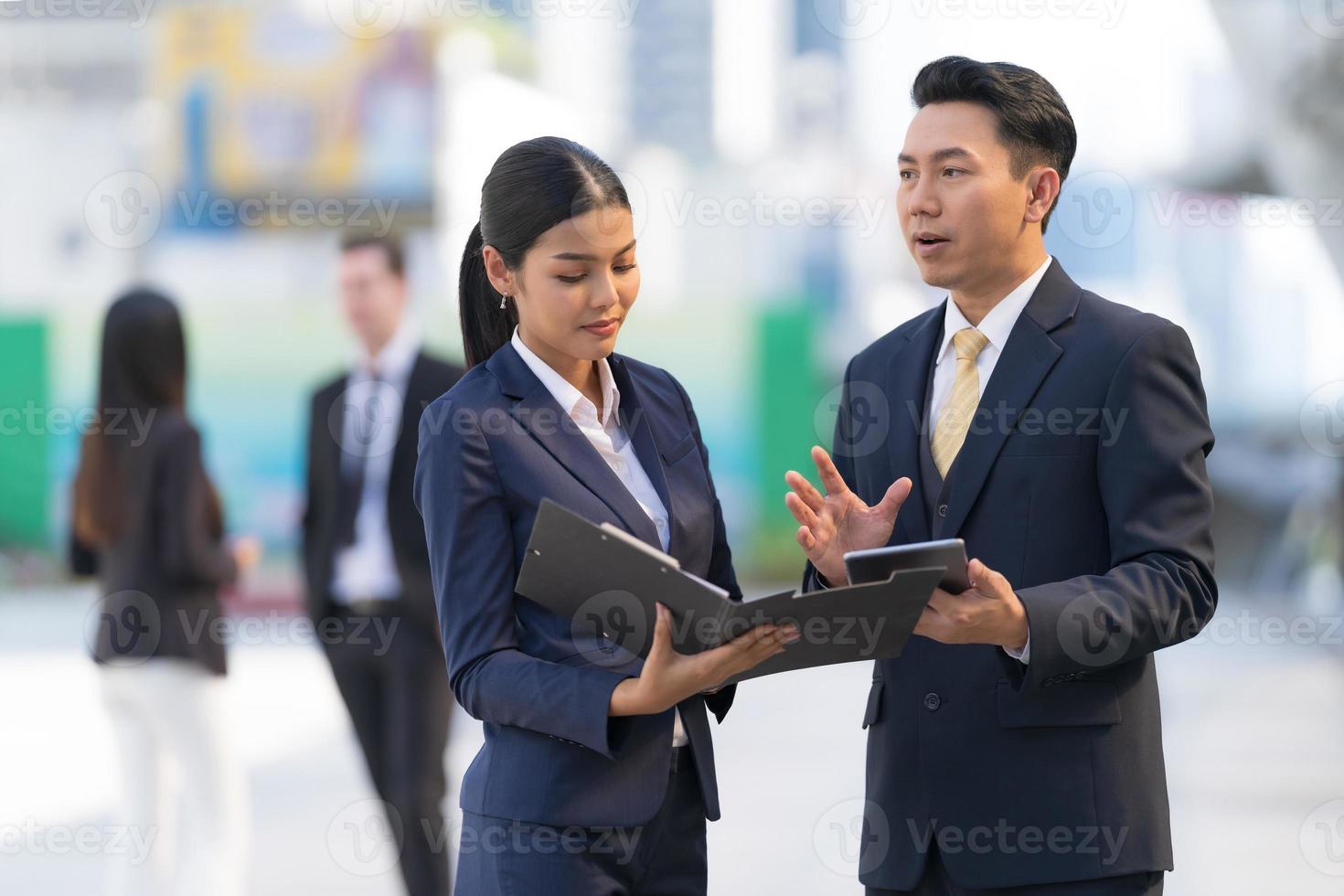 homme d'affaires mature utilisant une tablette numérique pour discuter d'informations avec une femme d'affaires photo