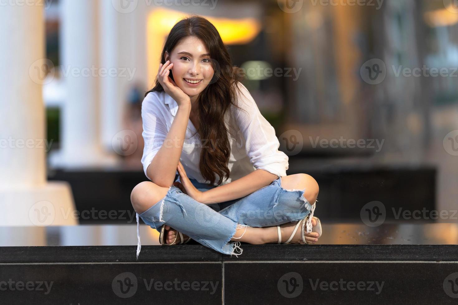 image d'une jeune femme heureuse assise sur le sol photo