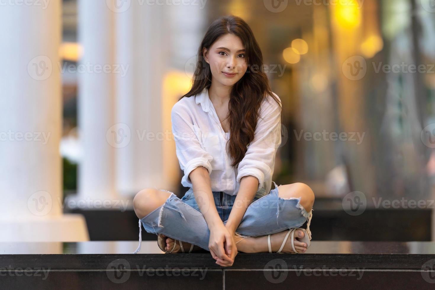 image d'une jeune femme heureuse assise sur le sol photo