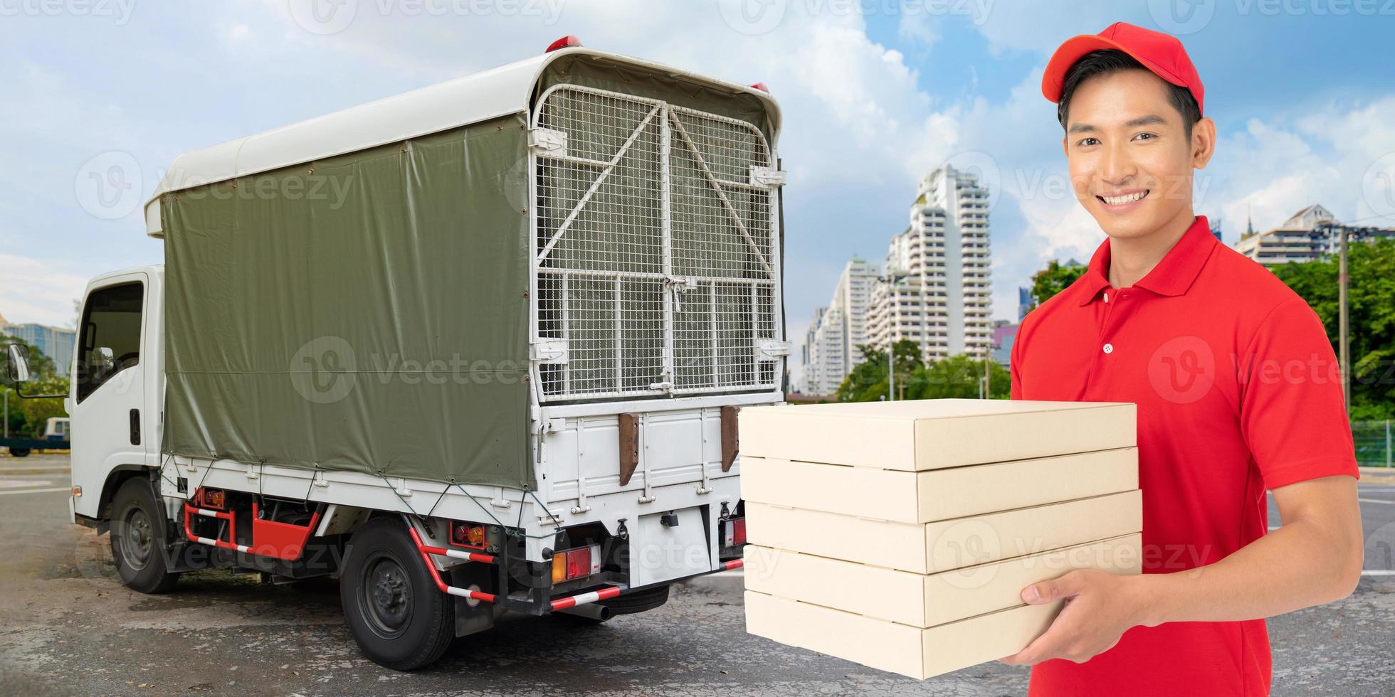 employé de livraison en t-shirt rouge masque uniforme tenant une boîte en carton vide photo