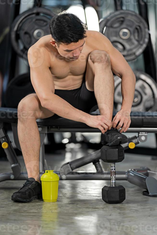 homme sportif s'entraînant avec des haltères dans une salle de sport, entraînement sportif de bodybuilder photo