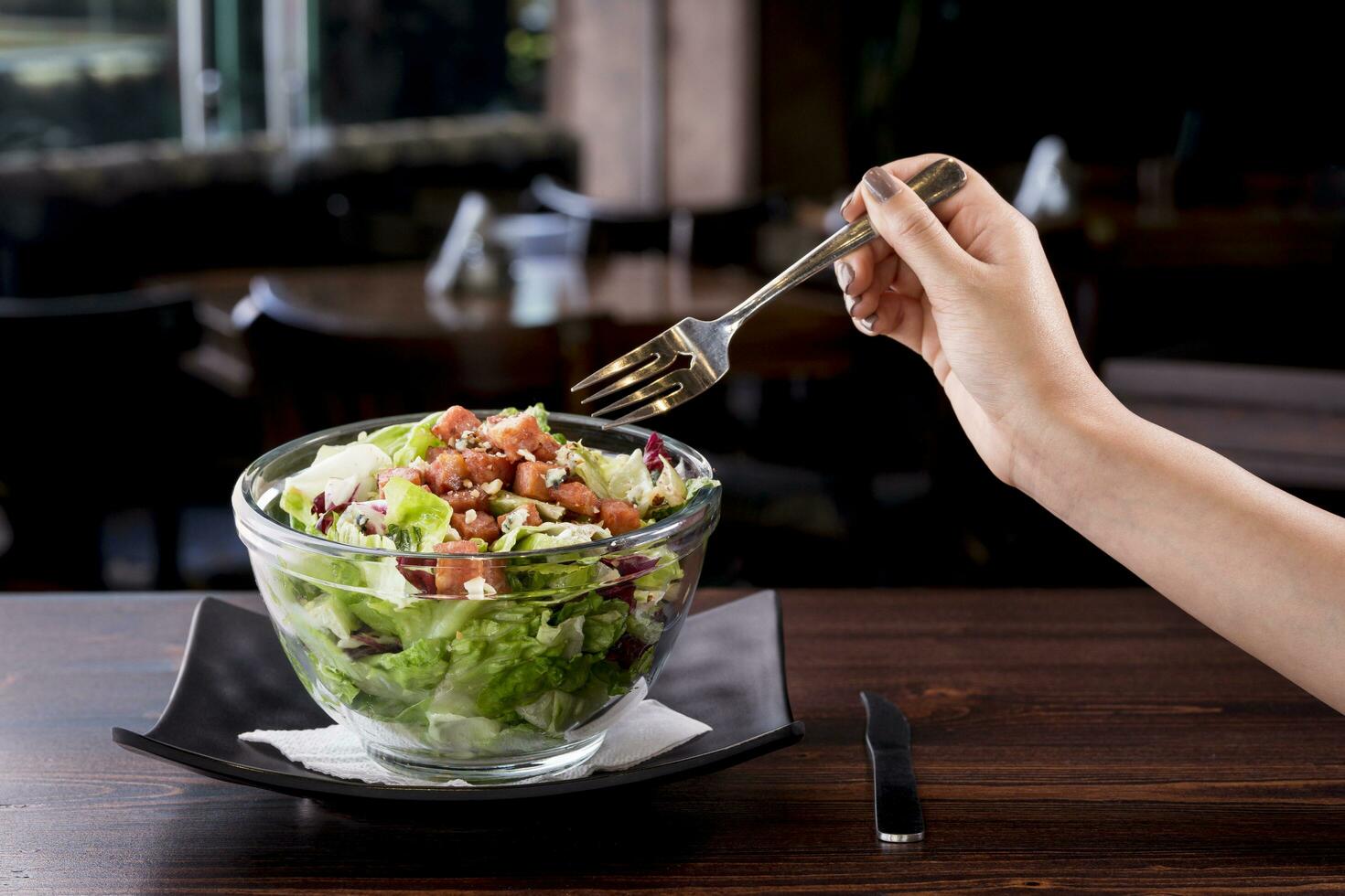 Jeune femme en mangeant délicieux thon salade dans une fantaisie restaurant, peu calorique nutritif repas - végétarien photo