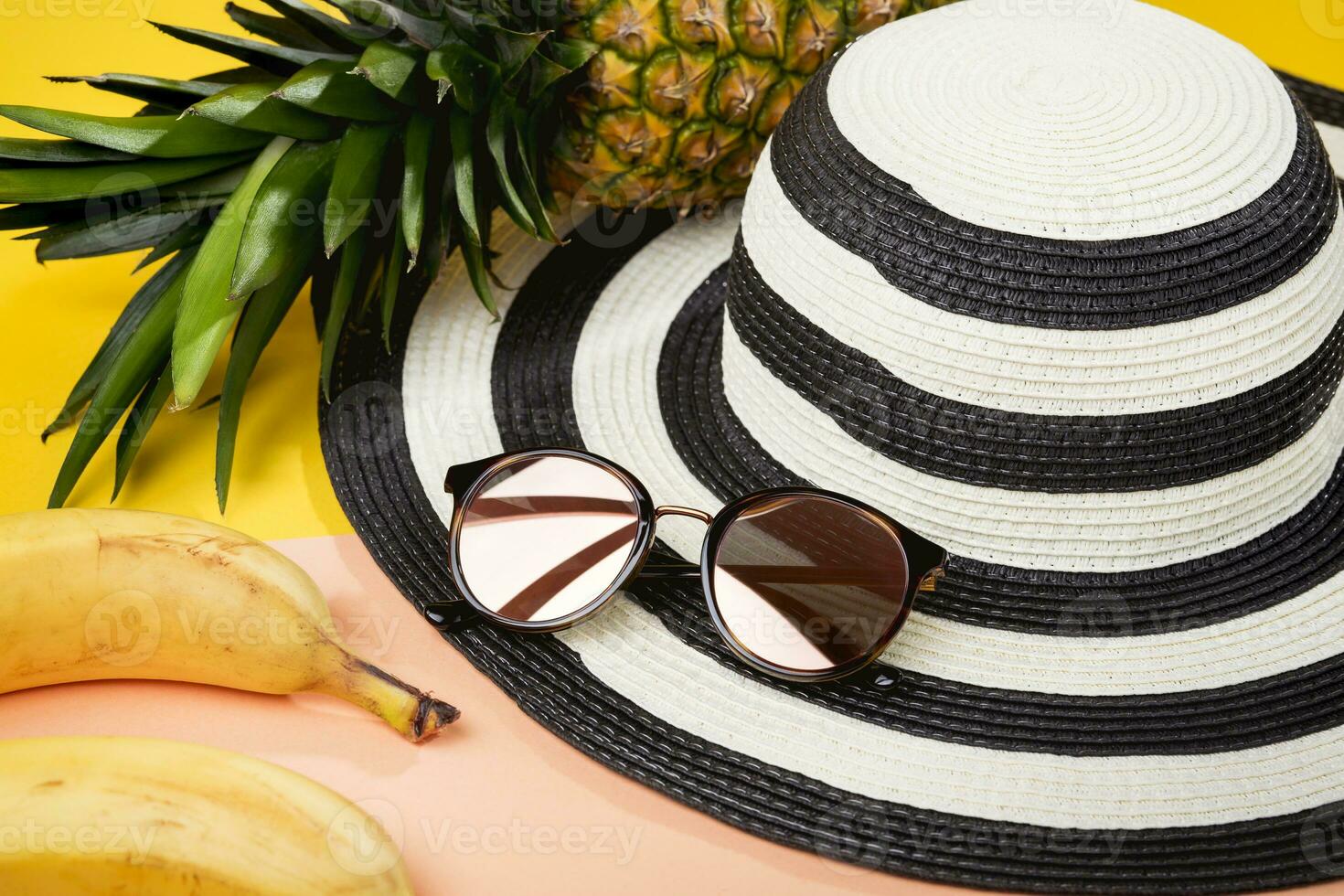 pack pour une plage vacances, aux femmes accessoires pour voyage, des lunettes de soleil et plage chapeau - délicieux tropical fruit, ananas et bananes. photo