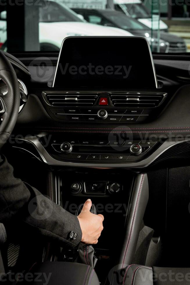 Jeune femme main en portant un automatique équipement levier conduite à l'intérieur une Nouveau voiture dans circulation photo