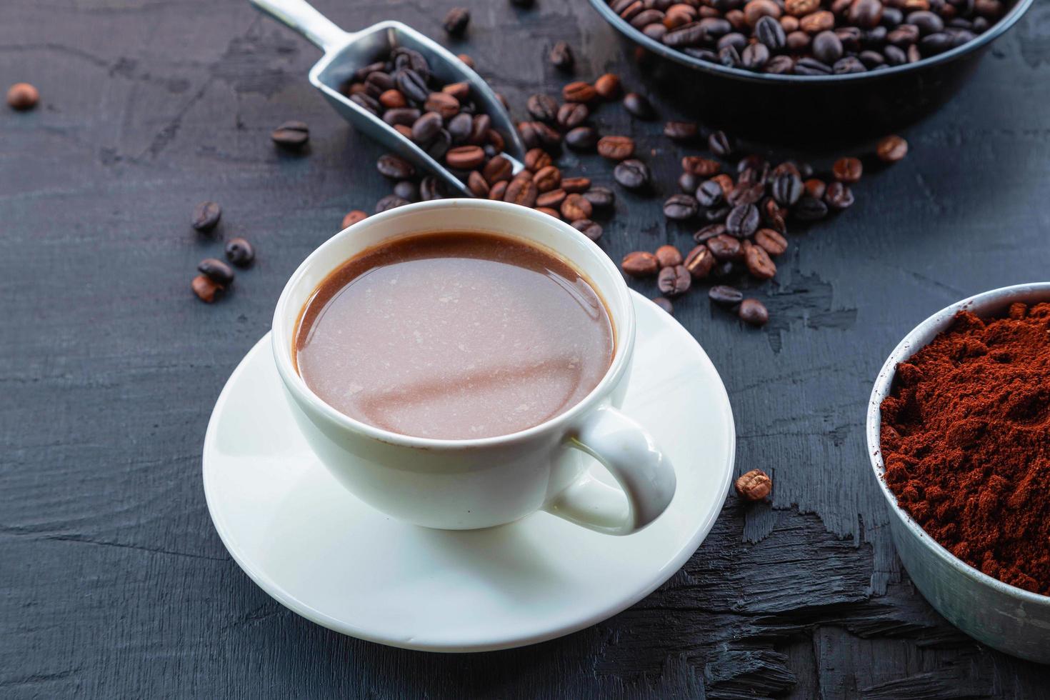 grains de café torréfiés avec de la poudre de café et des tasses à café. photo