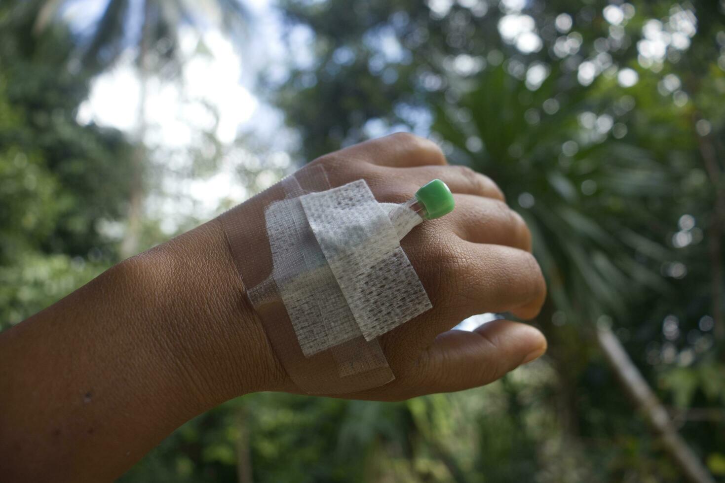 patient main avec bandage sur le sien bras dans le jardin. photo