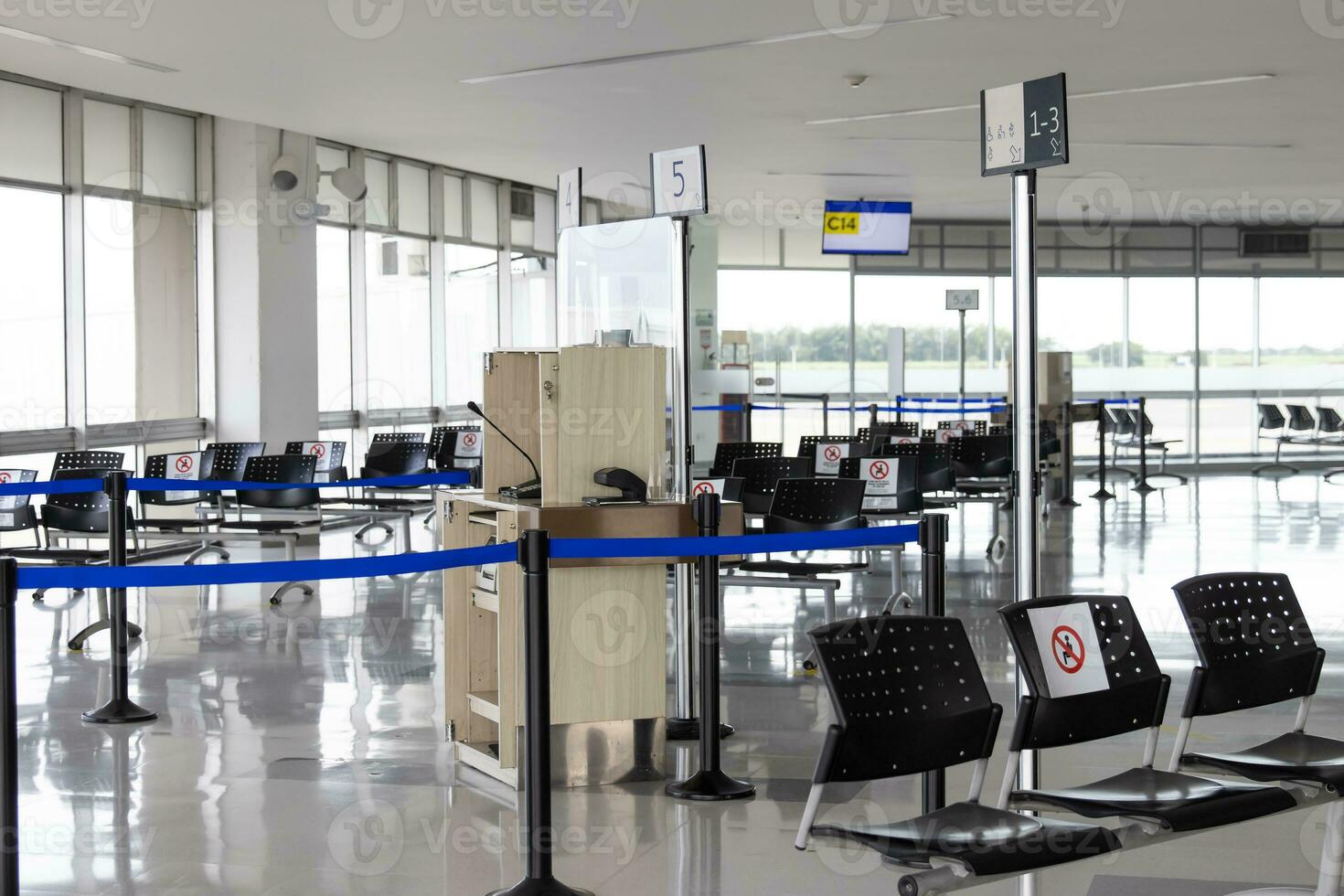 vide attend pièce à un aéroport pendant convoitise 19 pandémie avec social distanciation panneaux sur chaises photo