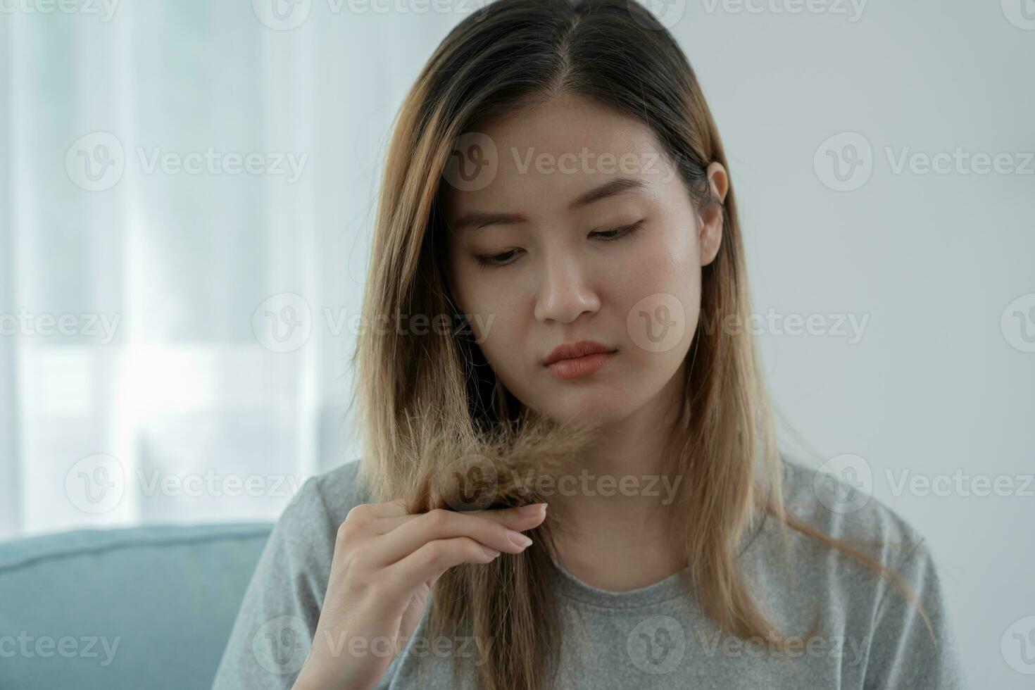 asiatique femme très triste et dérangé à la recherche à endommagé cheveux, cheveux perte, cheveux éclaircie problème, vitamine carence, calvitie, post-partum, biotine, zinc, menstruel ou endocrine troubles, hormonale déséquilibre photo