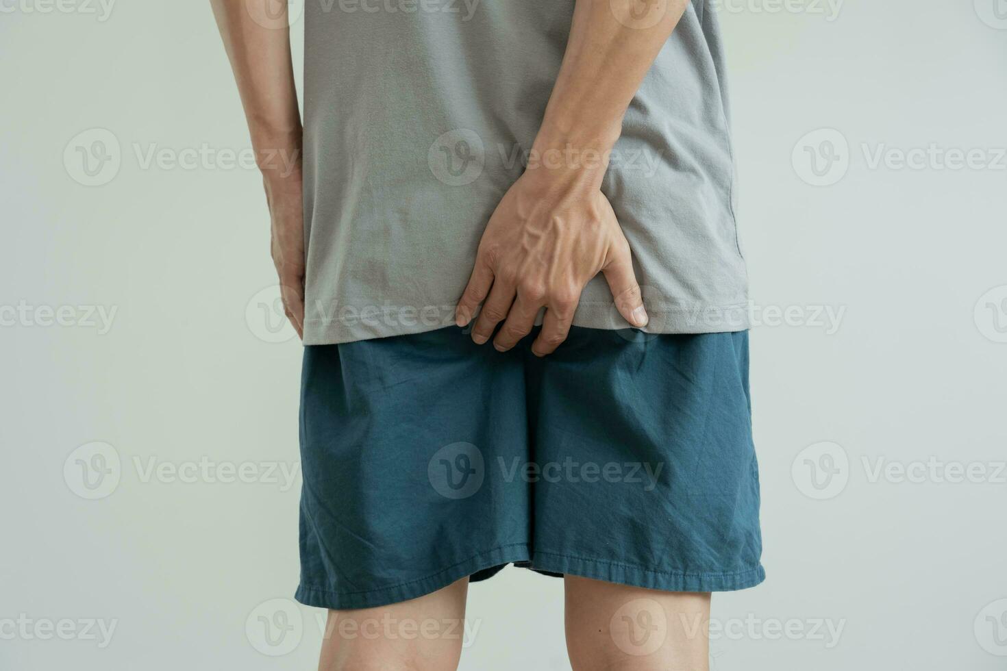 Masculin main en portant sa bas car ayant abdominal douleur et les hémorroïdes, santé se soucier, constipation, anatomique, Souffrance de douleur, abdominal, intestin problème, sanglant diarrhée, estomac mal, cancer photo