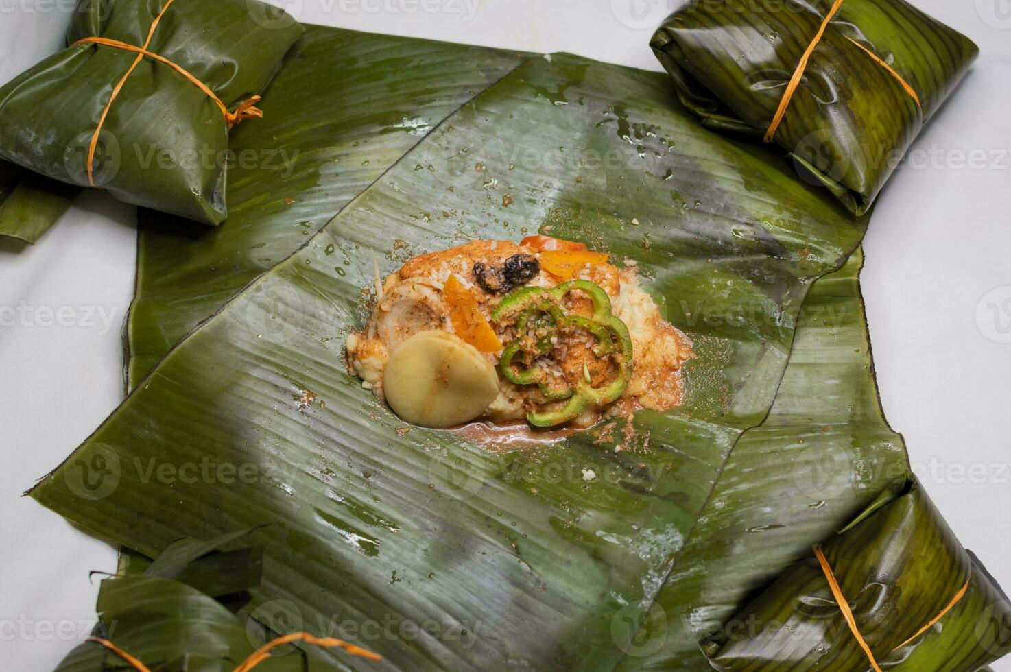 Haut vue de brut Ingrédients de le nicaraguayen nacatamal sur banane feuilles. brut Ingrédients pour le préparation de le traditionnel nacatamal, nacatamal Ingrédients sur banane feuilles photo