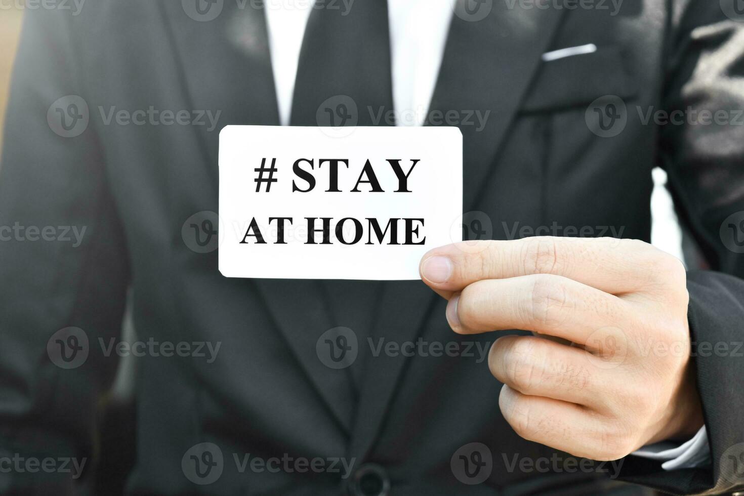 fermer de homme d'affaire main en portant papier carte avec rester maison. photo