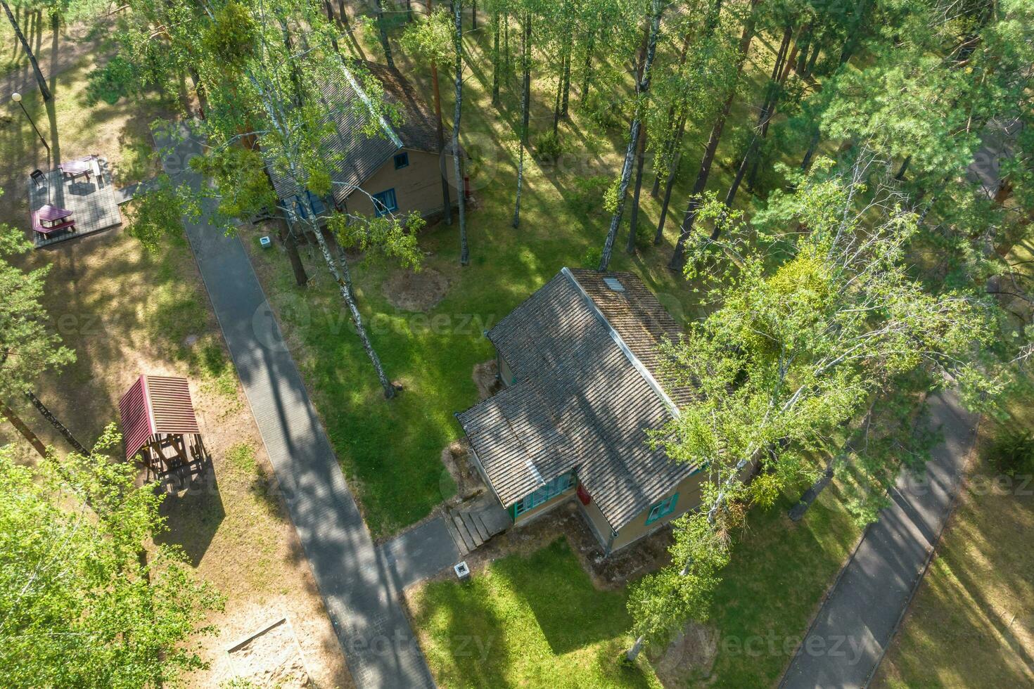 panoramique aérien vue de éco village avec en bois Maisons, gravier route, jardins et vergers photo