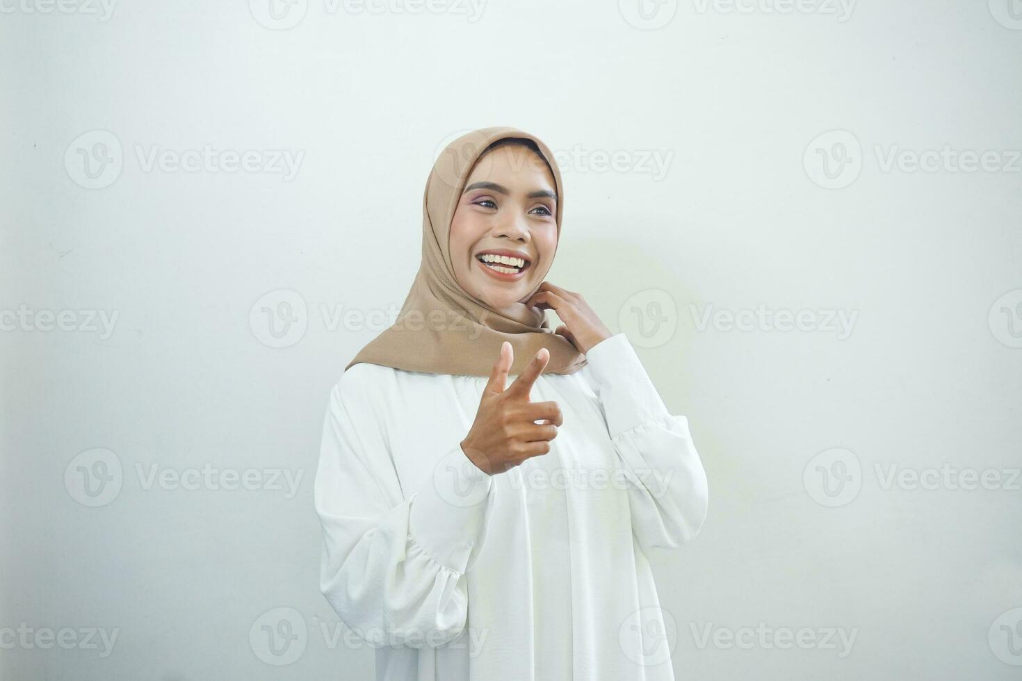 magnifique asiatique femme dans décontractée chemise et hijab montrer du doigt les doigts à Vide espace photo