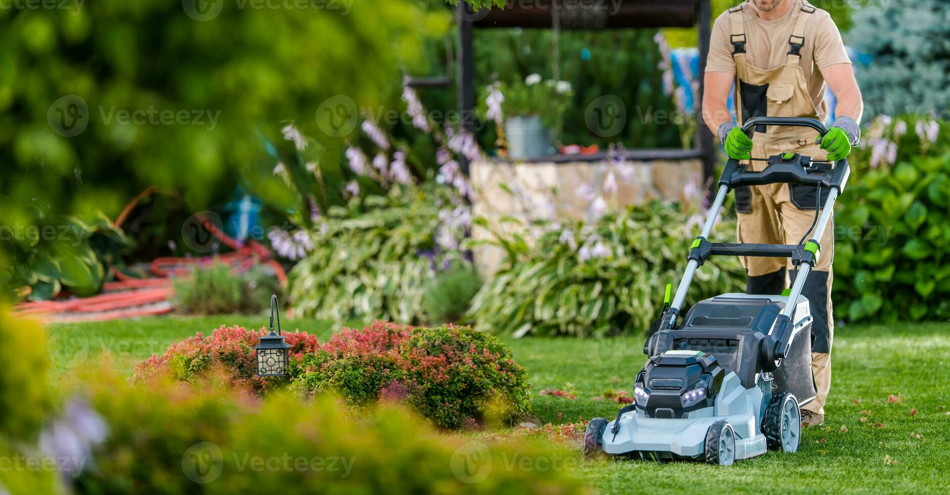 jardinier ouvrier garniture herbe en utilisant électrique tondeuse photo