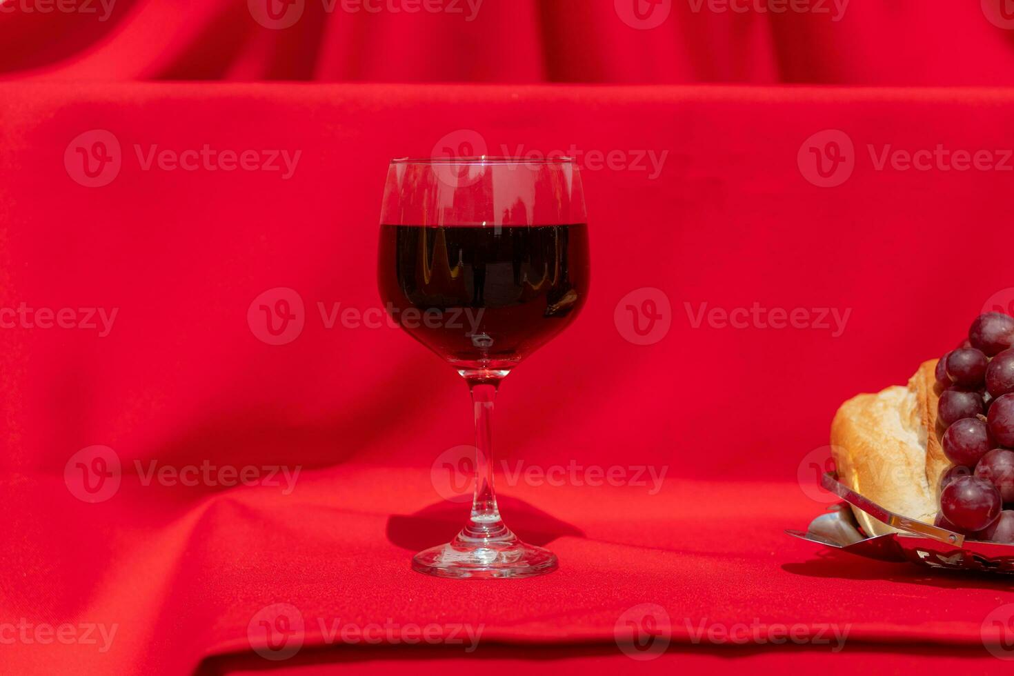 éléments de le dernier souper de Jésus pain, les raisins et du vin sur une rouge tissu avec dur éclairage photo