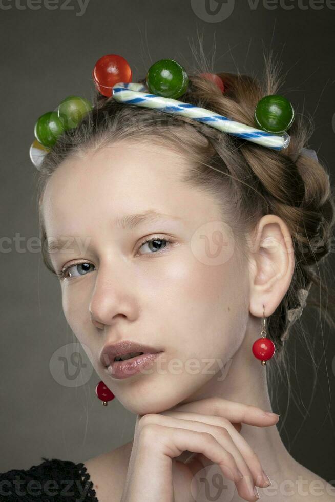 portrait de une marrant adolescent fille avec une couronne de bonbons sur sa diriger. photo