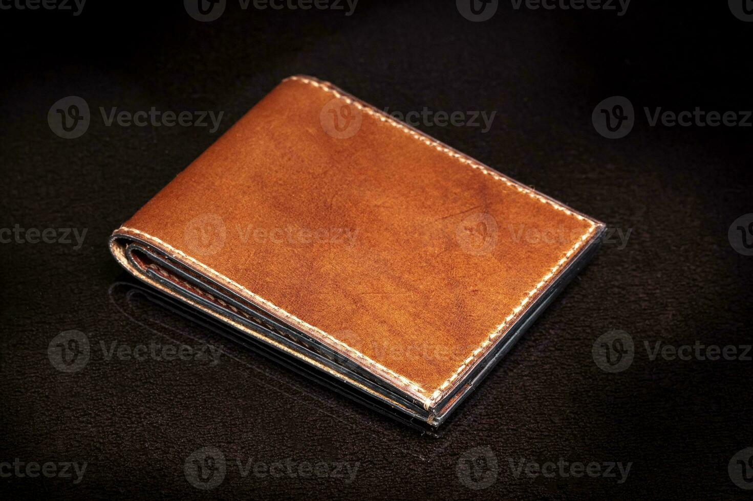 marron cuir portefeuille sur une foncé Contexte. photo
