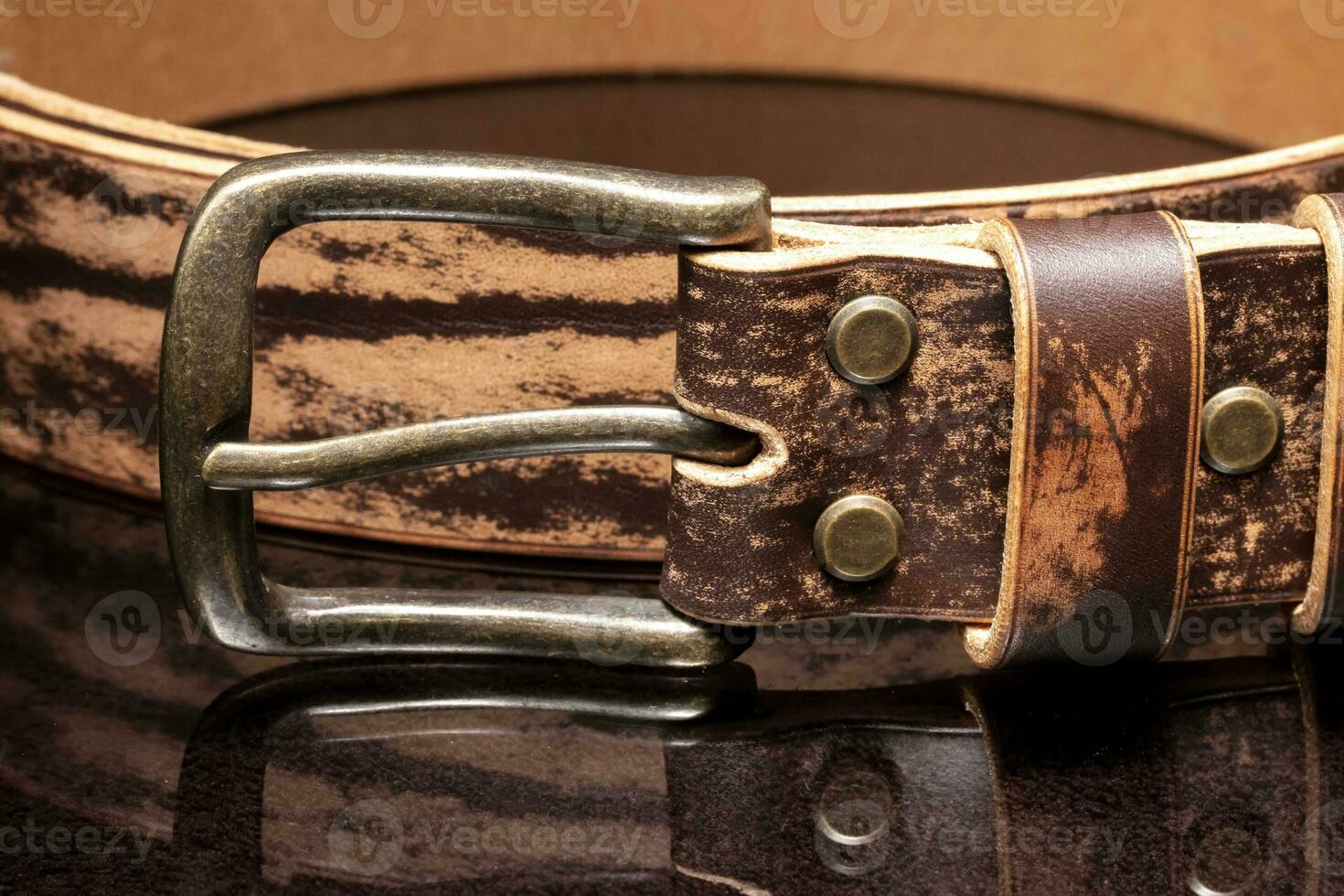 marron cuir ceinture avec éraflures et une métal Boucle sur une foncé Contexte. photo