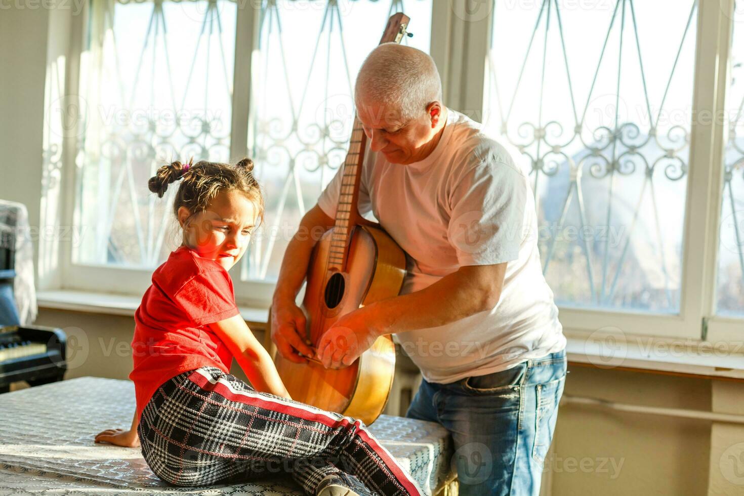 fermer homme main en changeant cordes sur le sien vieux acoustique guitare. photo