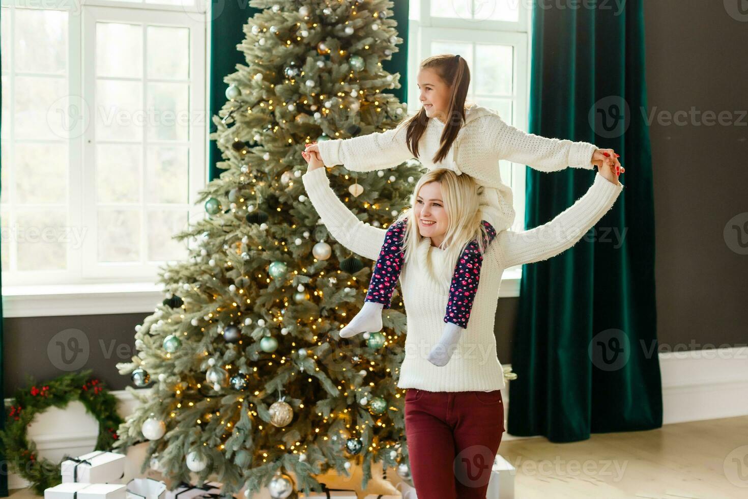 mère et fille décorer Noël arbre et ayant amusement. concentrer sur le fille photo