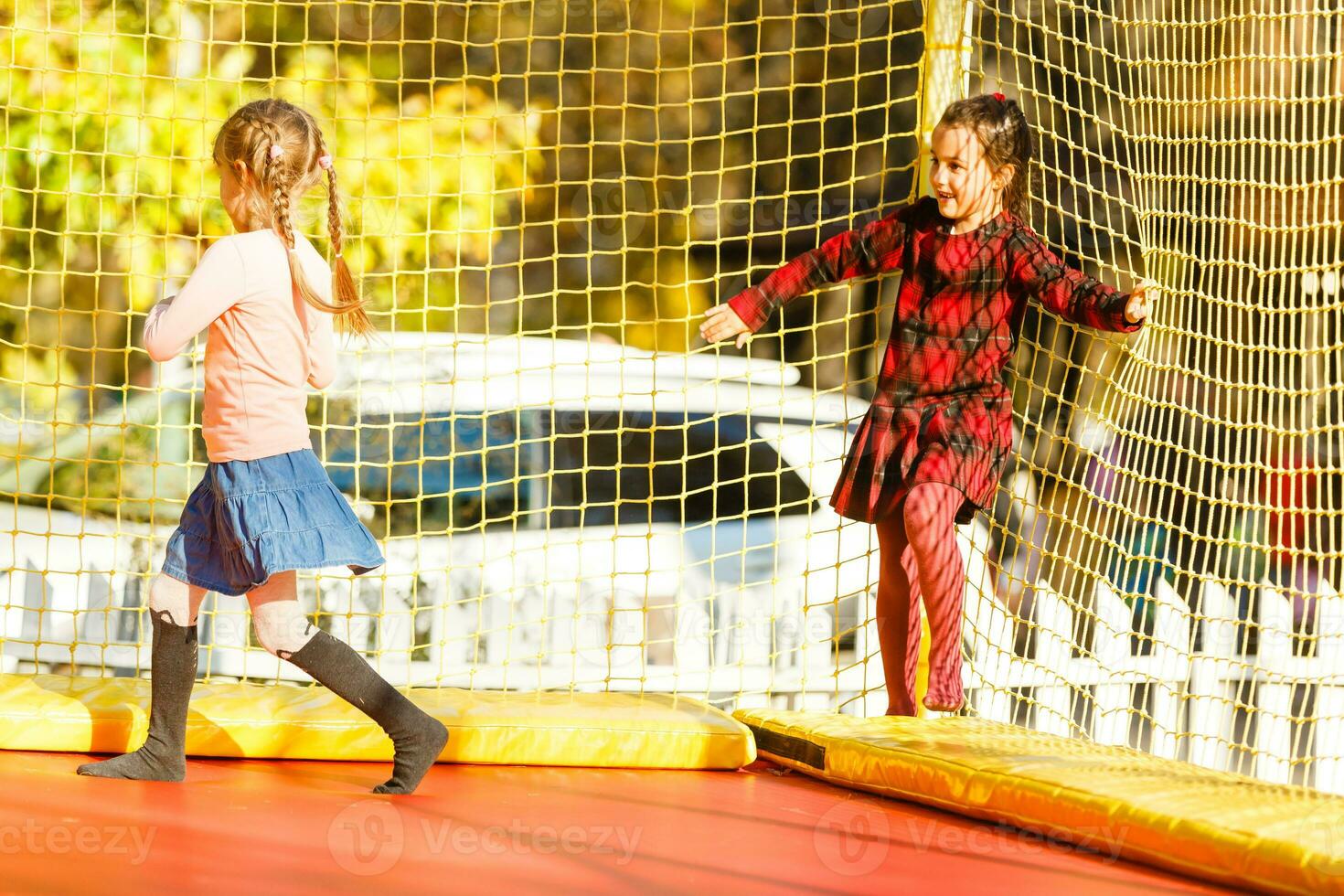 content école fille sauter sur trampoline dans le l'automne parc photo