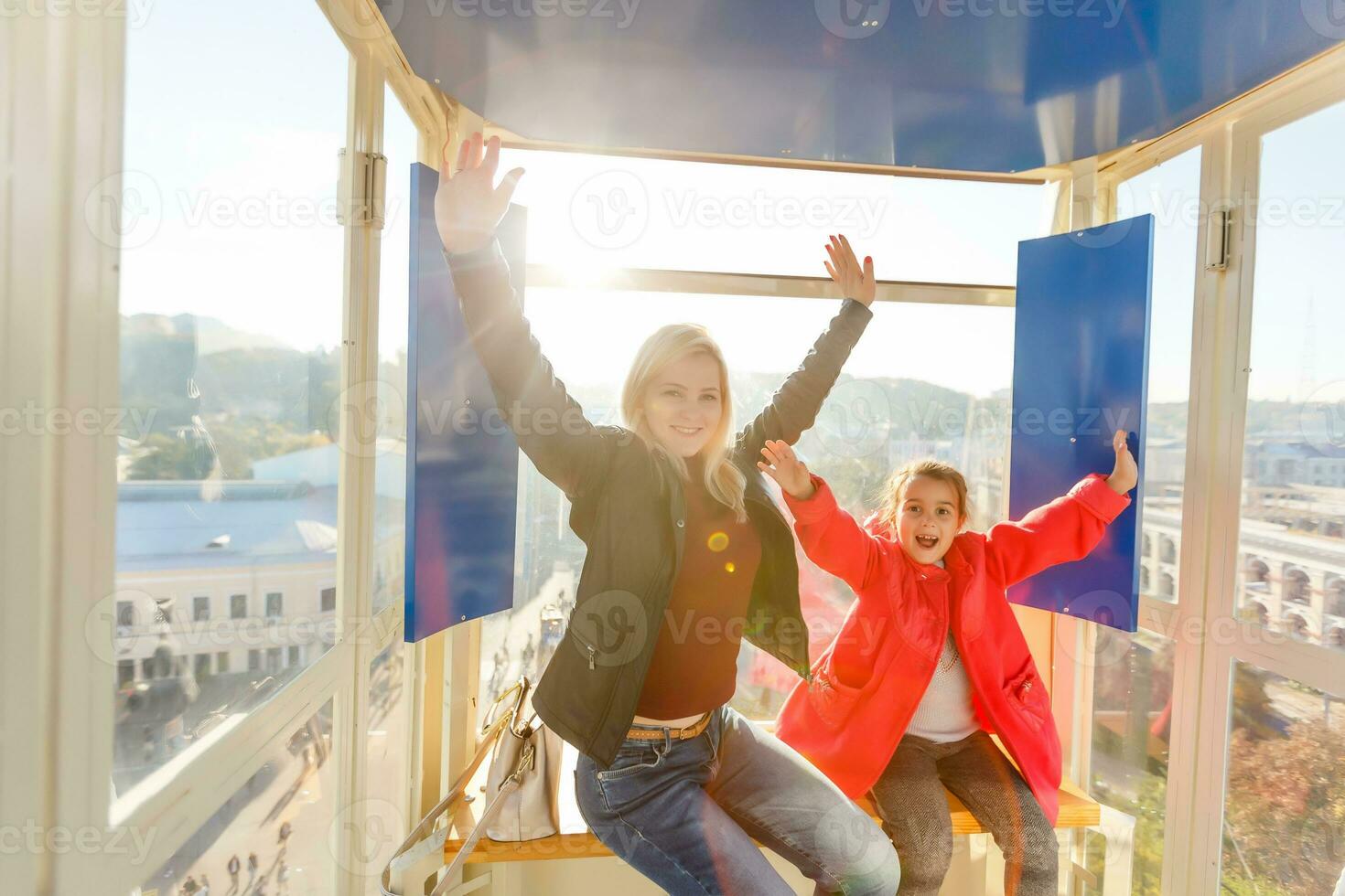 Jeune mère avec sa bambin fille prendre plaisir étant sur ferris roue photo