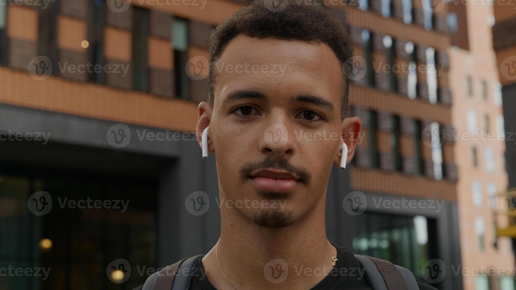 Portrait de jeune homme portant des écouteurs sans fil photo