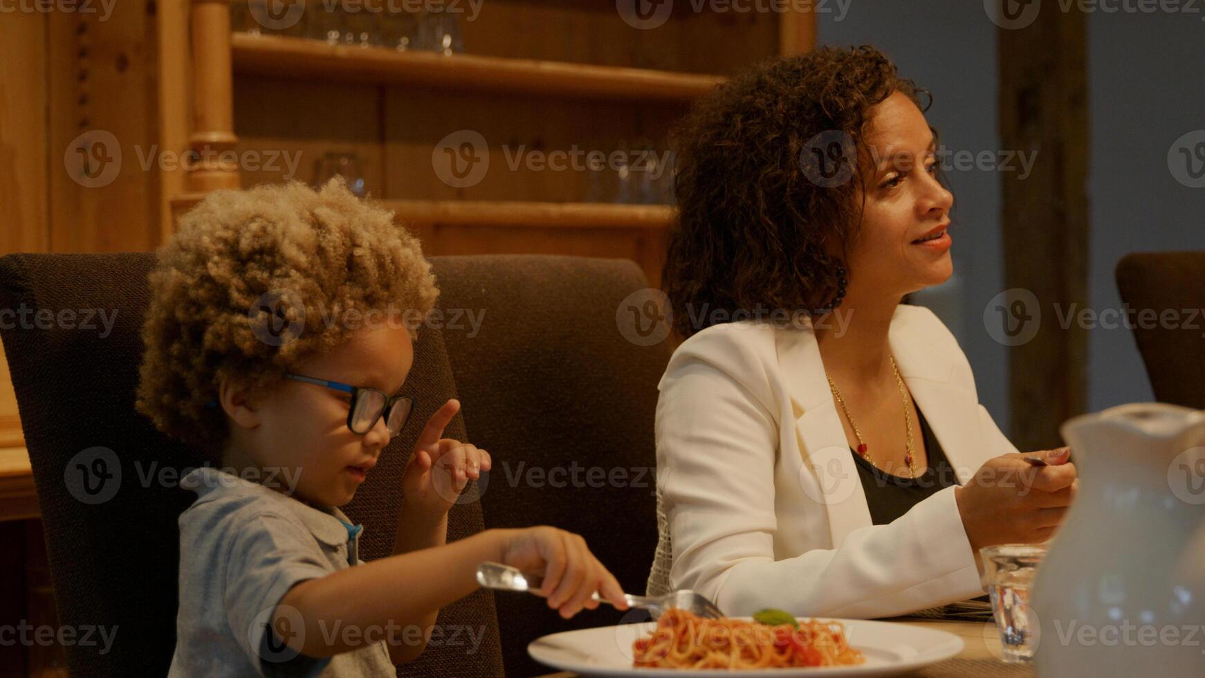 mère et fils appréciant les pâtes au dîner photo