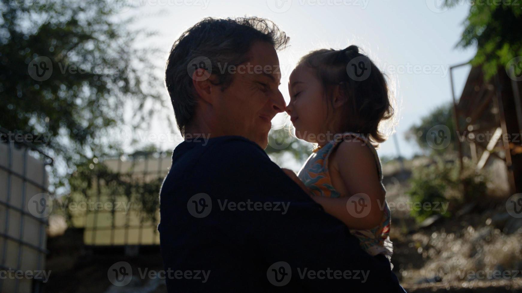portrait de père tenant sa fille au soleil photo
