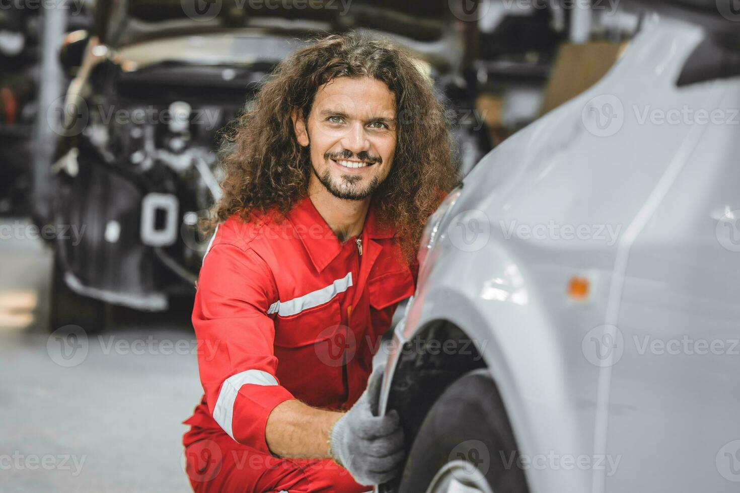 hispanique Masculin Personnel ouvrier travail dans auto atelier content souriant prendre plaisir travail entretien voiture pneu remplacer photo