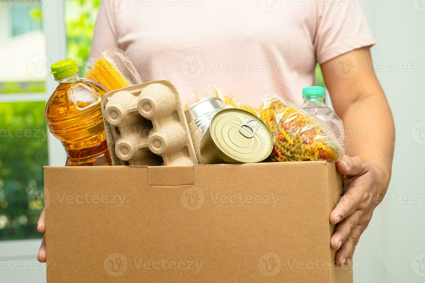 des bénévoles mettent divers aliments secs dans une boîte de dons pour aider les gens. photo