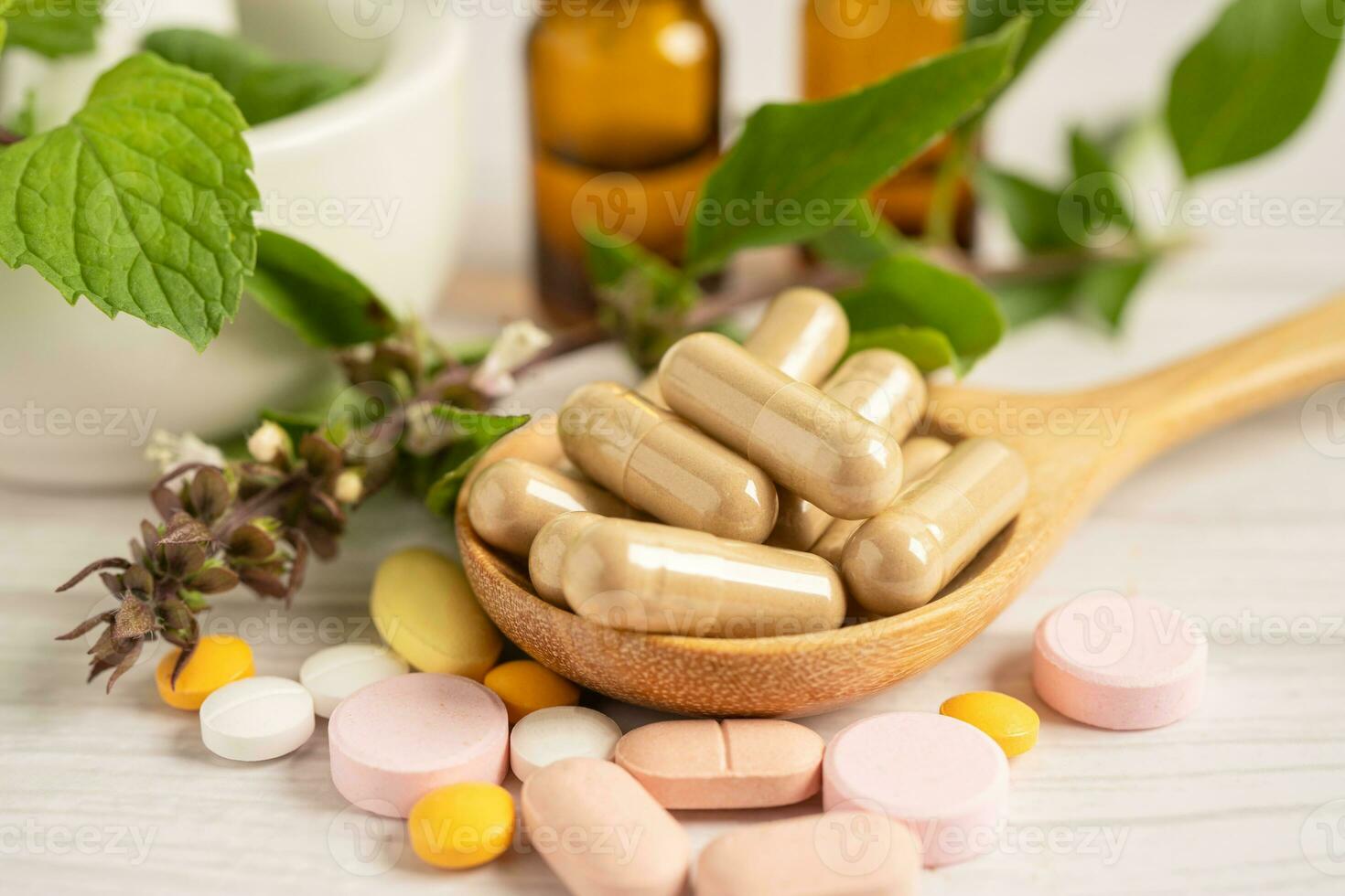 capsule biologique à base de plantes de médecine alternative avec vitamine e oméga 3 huile de poisson, minéral, médicament avec feuilles d'herbes suppléments naturels pour une bonne vie saine. photo