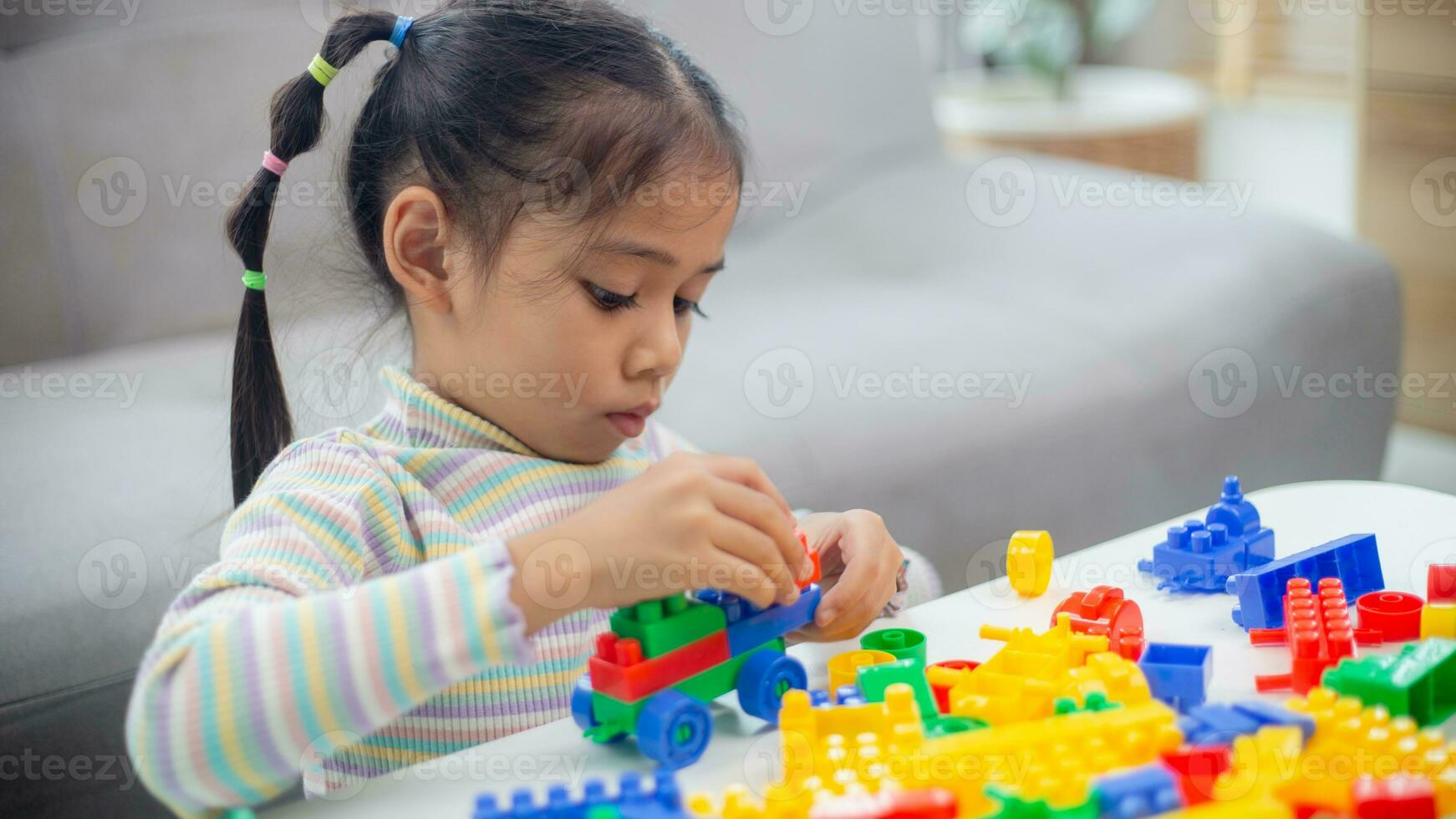 adorable petite fille jouant des blocs de jouets dans une pièce lumineuse photo