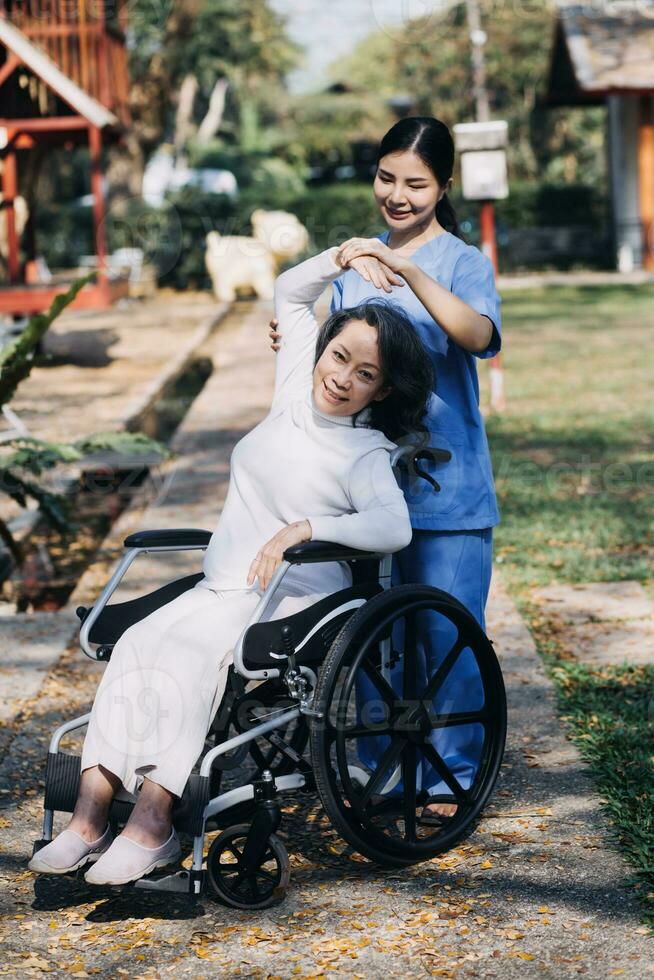 jeune physiothérapeute asiatique travaillant avec une femme âgée sur la marche avec un déambulateur photo